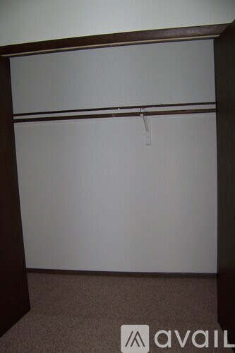 A room with a white wall and a brown carpet.