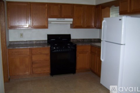 A kitchen with brown cabinets and a black stove top oven.