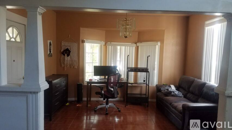 A living room with a couch, chair, and desk.
