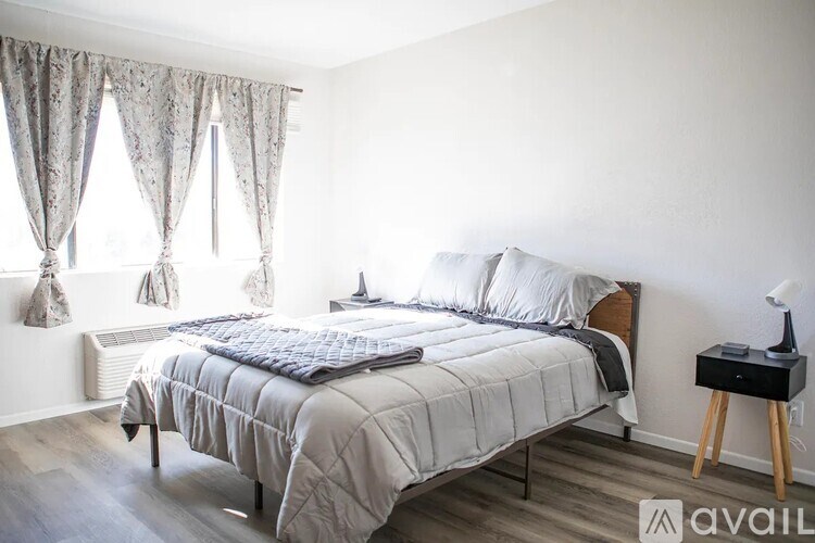 A bedroom with a large bed and a nightstand.