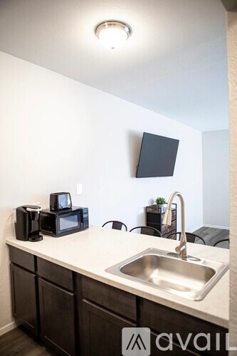 A kitchen with a sink and a microwave on the counter.