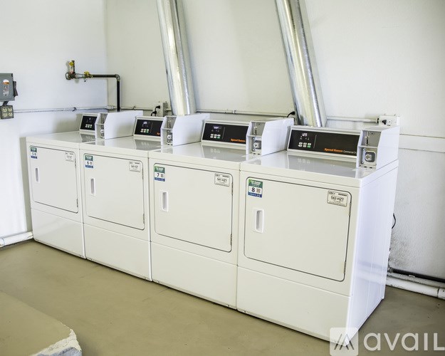 A row of white industrial machines with digital displays on top.