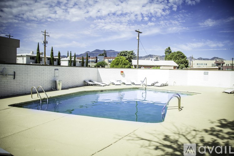 A pool with a blue water and a white wall.
