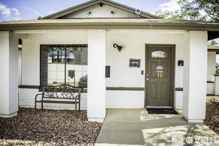 A house with a grey door and a bench outside.
