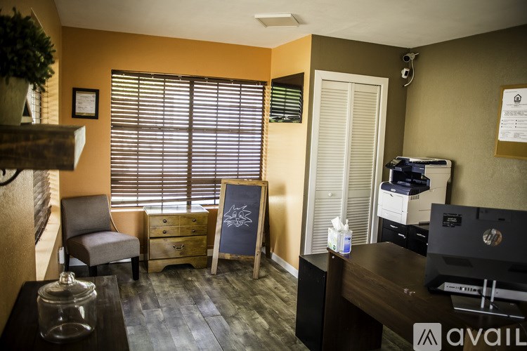 A room with a desk, chair, and printer.