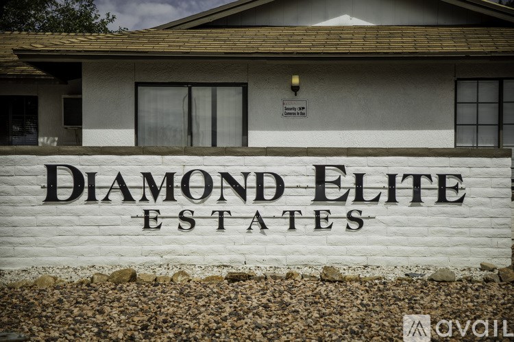 A sign for Diamond Elite Estates in front of a house.