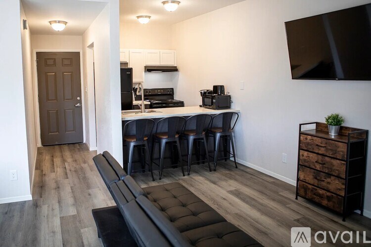 A kitchen with a black countertop and a black couch.