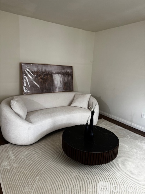 A living room with a couch, chair, coffee table, and television.