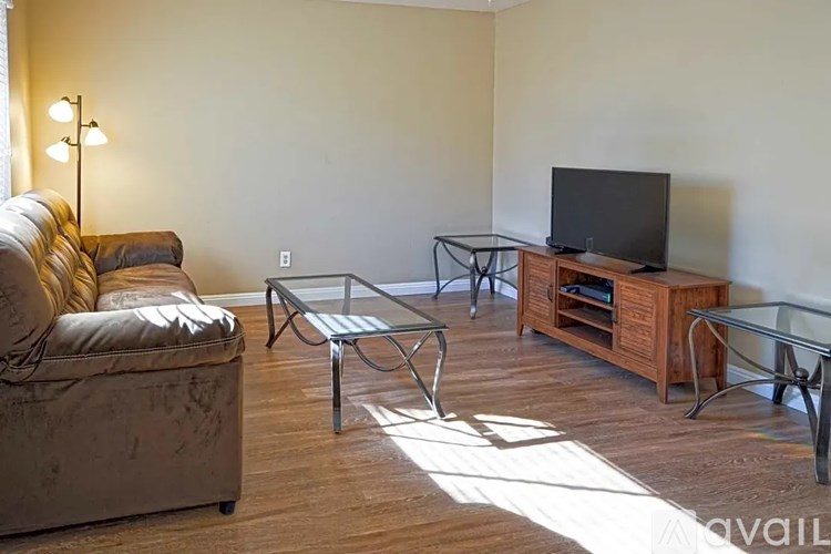 A living room with a couch, chair, coffee table, and television.