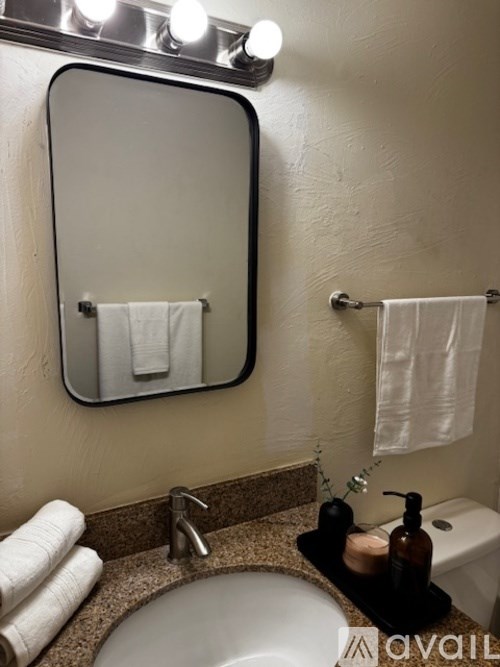 A kitchen with a black counter top and a white microwave.