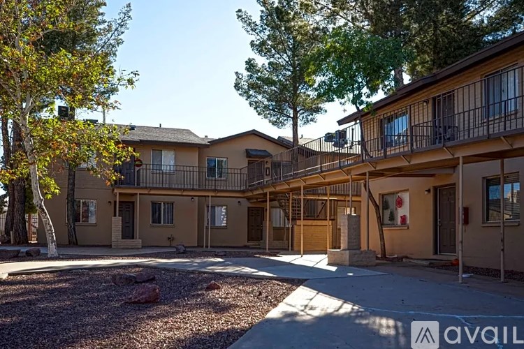 A building with a balcony and a tree in front of it.