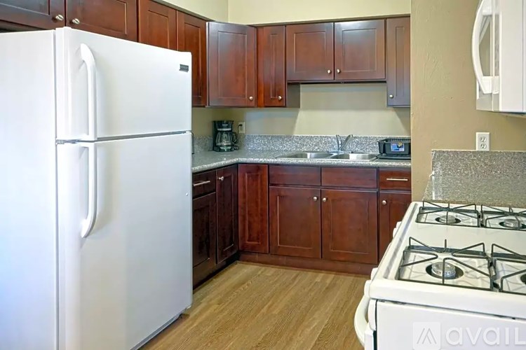 A kitchen with a white fridge and a white gas stove.