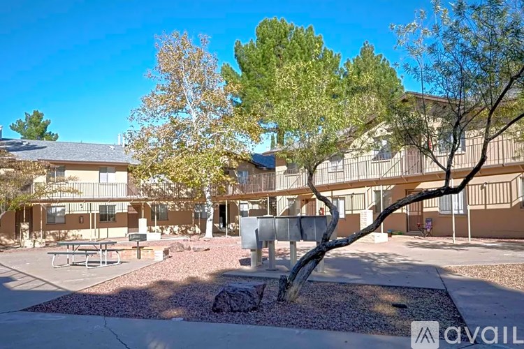 A courtyard with a tree and a bench in front of a building.