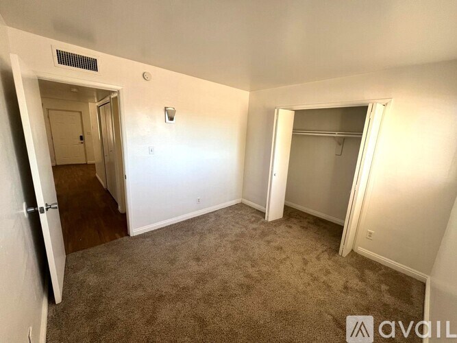 A carpeted room with a doorway leading to another room.