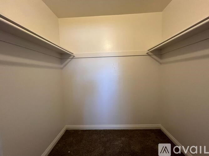 A small, empty room with a carpeted floor and white walls.
