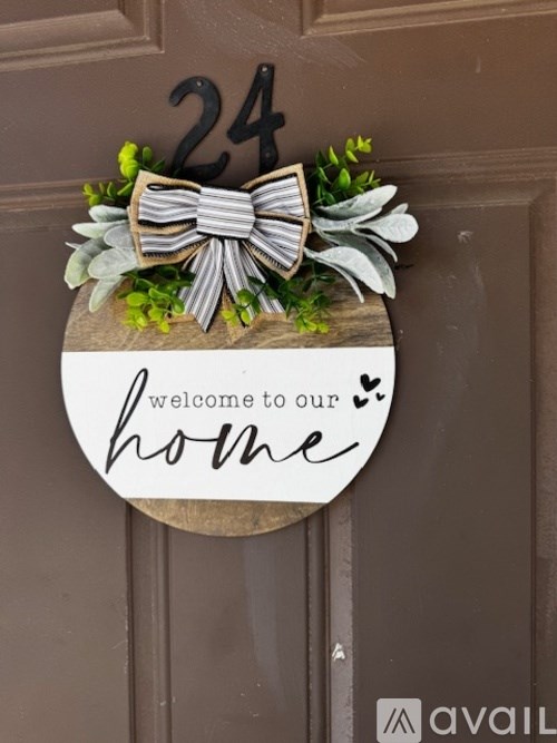 A door numbered 24 with a decorative sign that says "welcome to our home".