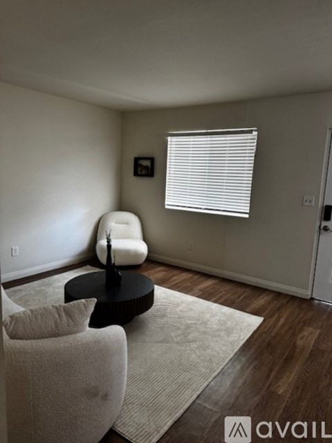 A kitchen with a white fridge and a dining table with chairs.