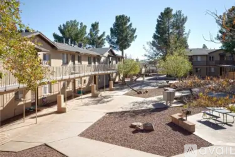 A sunny day at a residential complex with houses and trees.