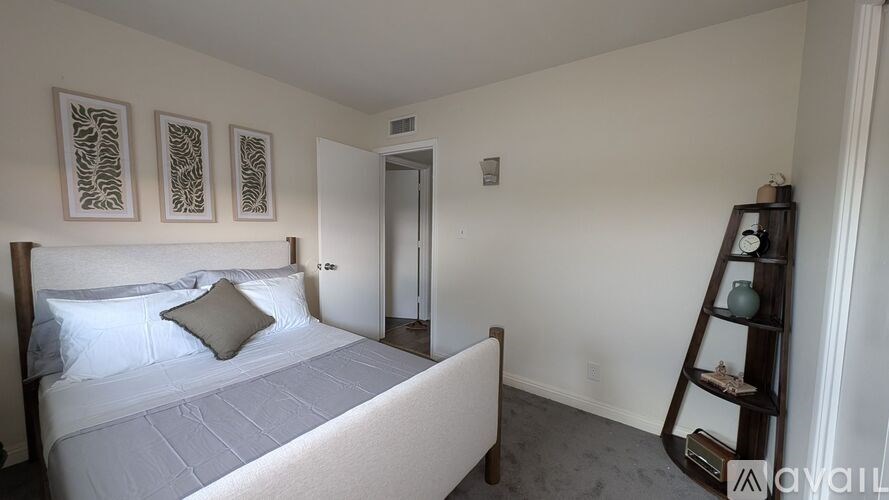 A carpeted room with a doorway leading to another room.