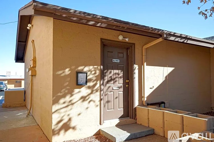 A small house with a brown door and a small porch.