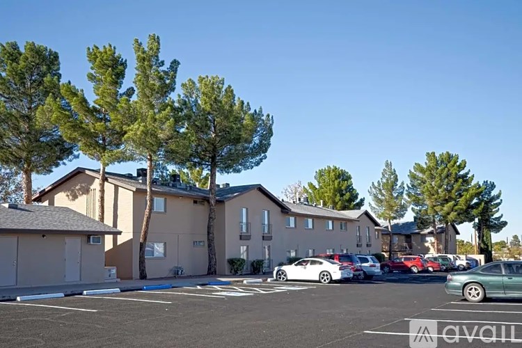 A parking lot with cars and a building in the background.
