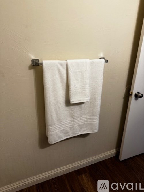Two white towels hanging on a towel rack.