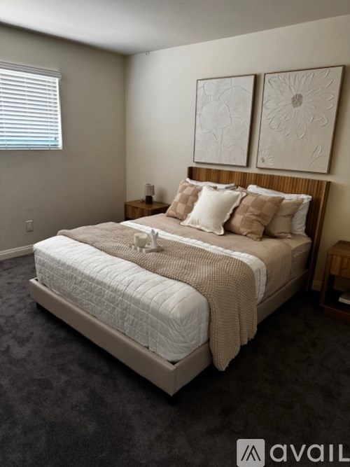 A bedroom with a large bed and two wall art pieces.