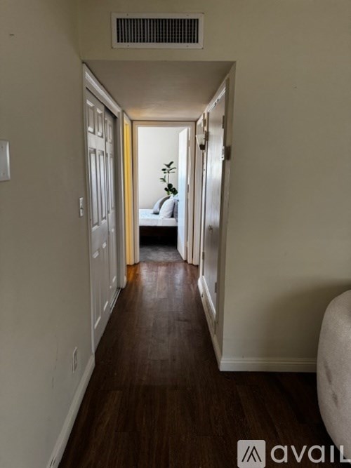 A long hallway with a bedroom at the end.