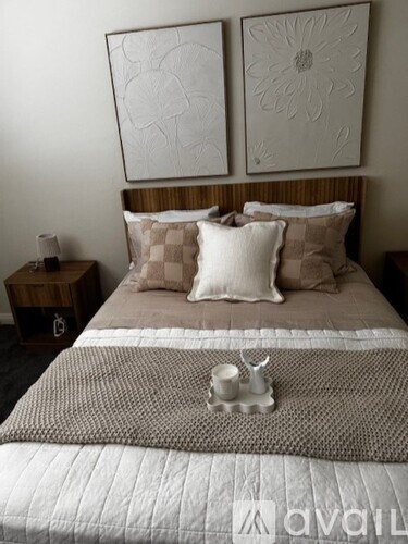 A bed with a quilted cover and a pillow with a checkered pattern.