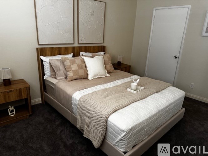 A neatly made bed with a white duvet and pillows in a room with a wooden headboard.
