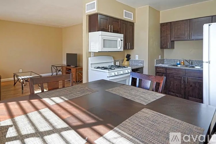 A kitchen with a black counter top and a white microwave.