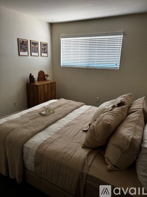 A bed with a striped comforter and two pillows.