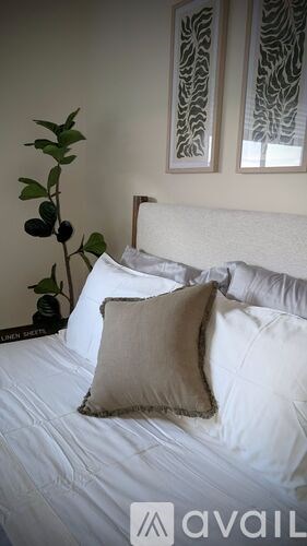 A bed with a white pillow and a brown pillow case.