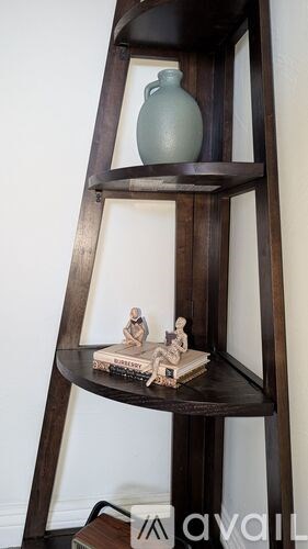 A shelf with a vase and a small sculpture on it.