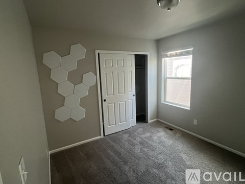 A room with a white door and a hexagonal wall decoration.
