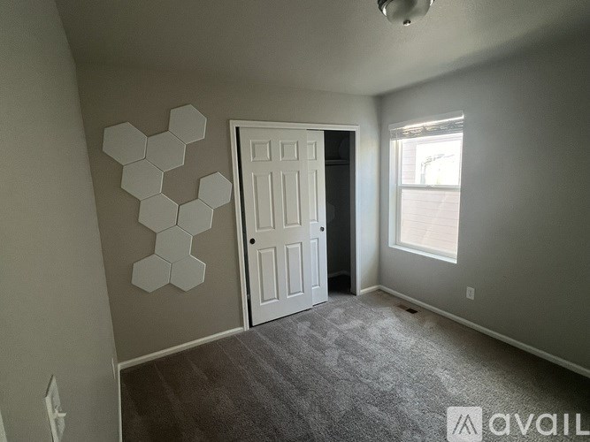 A room with a white door and a hexagonal wall decoration.