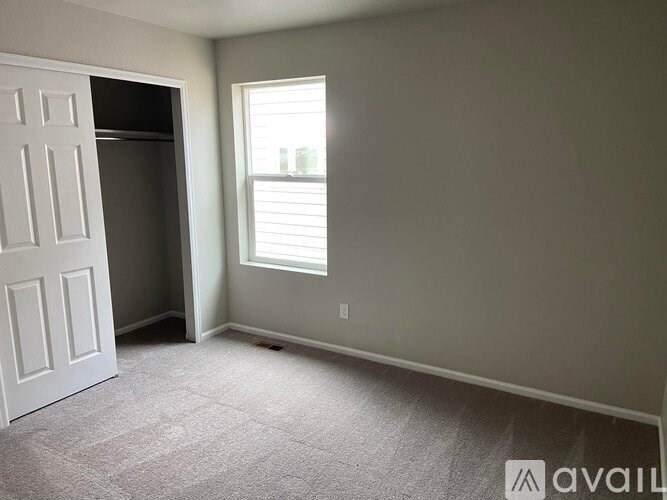 A room with a white door and a window with blinds.