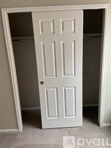 A white door is open to a dark room.