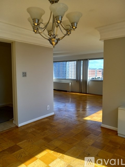 A room with wooden flooring and a chandelier.