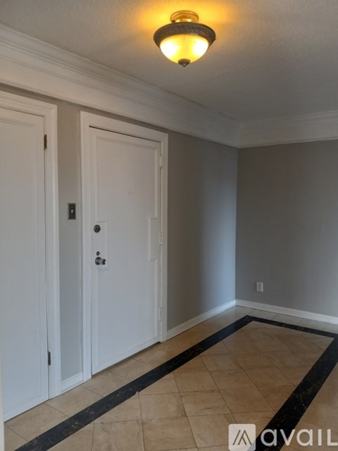 A room with a white door and a light on the ceiling.