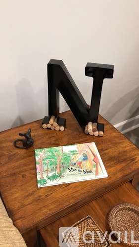 A wooden table with a large letter N and a small picture of a woman on it.