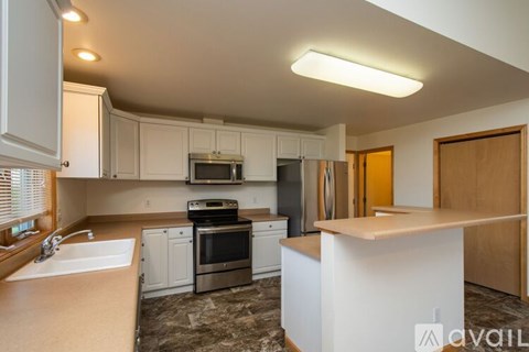A kitchen with white cabinets and a wooden island.