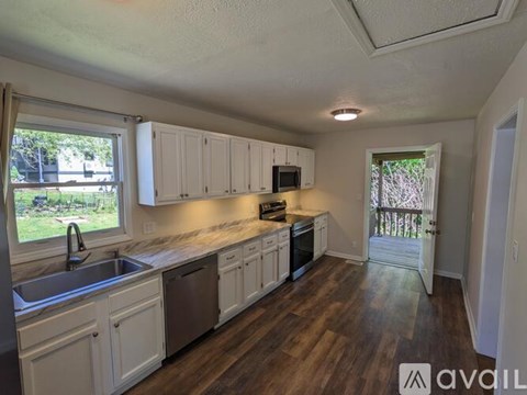 A kitchen with white cabinets and a sink.