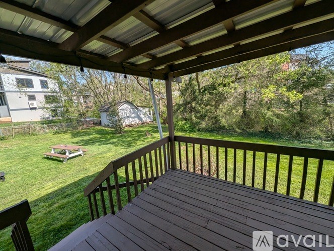 A wooden deck with a view of a backyard and trees.