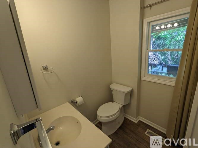 A bathroom with a toilet, sink, and mirror.