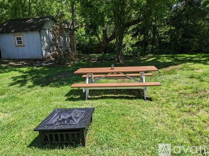 A picnic table and crate are on a grassy lawn.