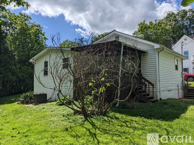 A white house with a tree in front of it.