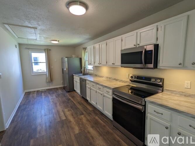 A kitchen with white cabinets and a black stove top oven.
