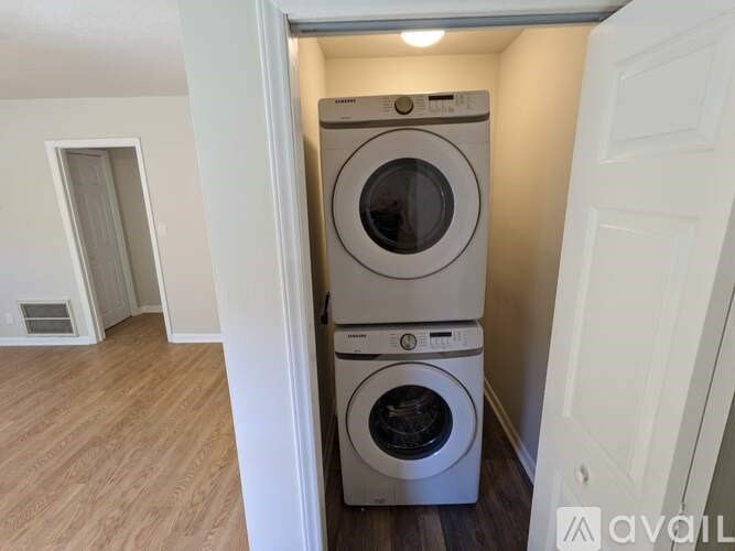A stack of two washing machines in a small laundry room.