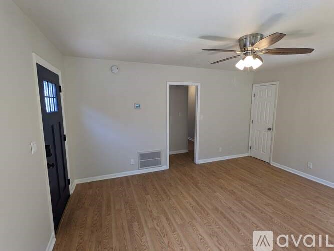 A room with a ceiling fan and wooden flooring.